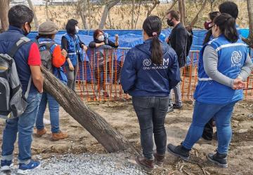 Hombres y mujeres en una reunión sobre el terreno para preparar a las personas y familias que viven en el campo informal de Matamorosm México, para su entrada en EE UU.