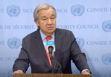 رجل يقف على منصة ويتحدث أمام الميكروفون.