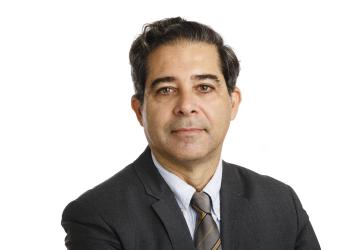 A man in a tie and suit, a UN official, smiles for the camera.