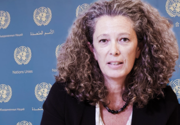 A woman in a black shirt against a blue background with UN logos