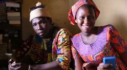 شاب وشابة من السنغال ينظران إلى الكاميرا وهما يمسكان بهاتفهيما المحمولين.