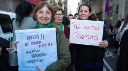 متظاهرتان تحملان لافتات بينما تبتسمان للكاميرا.