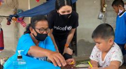 Rasa Pattikasemkul, une volontaire de l'UNICEF (au centre), s'entretient avec un jeune garçon lors d'un rare face-à-face pendant le confinement mis en place en réponse à la pandémie de COVID-19.