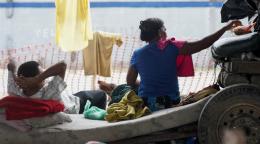 Un homme est à moitié allongé sur un matelas à gauche de l’image. Une femme est assise à sa droite. On leur a porté secours lors de la tempête tropicale qui a frappé le Honduras.