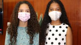 Anyah Spencer Maia and Victoria Roberts Gonçalves Gomes, age 10 stand side-by-side facing the camera wearing face masks.