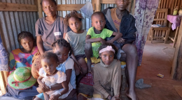 Fagnosea and Masy and their family sit together inside their home.