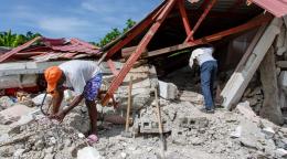 Two men examine the rubble of a collapsed building after the 7.2 magnitude earthquake.