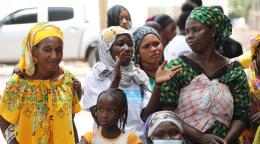 العديد من النساء والأطفال يتحدثون في الشارع.