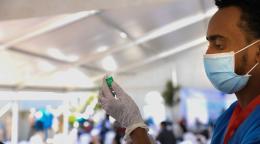 عامل رعاية صحية يُعدّ لقاحًا في خلال أول حملة تطعيم عبر مرفق كوفاكس في إثيوبيا.