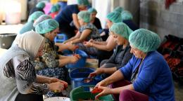 Las mujeres de Krusha/Kruša se sientan juntas en el suelo mientras hacen ajvar.