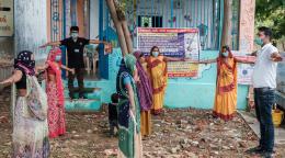 تقف مجموعة من الأشخاص ويفتحون أذرعهم لممارسة التباعد الاجتماعي.