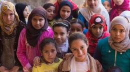 A large group of girls look directly at the camera.