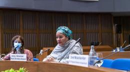 امرأة تتحدث أمام ميكروفون في اجتماع.