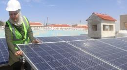 Una mujer está arreglando los paneles solares.