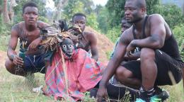 On the outskirts of an Ivorian forest, three young men are crouching on the ground around a traditional mask. They are about to participate in a "mask race" tournament in the county of Biankouma, Côte d'Ivoire.