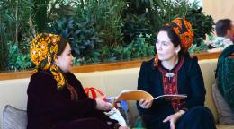 Две женщины обсуждают публикацию на мероприятии.