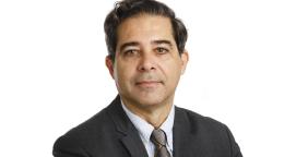 A man in a tie and suit, a UN official, smiles for the camera.