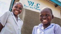 刚果民主共和国西部开赛省卡南加迪科莱拉伊小学厕所外的两名学生卫生队员在面对镜头微笑。