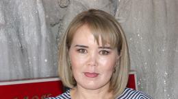 Woman in a striped shirt in front of a grey background