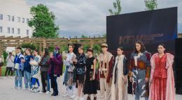 A line of people in fashionable colourful clothes standing against a black and green background