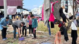 A group of displaced Gazans wash and hang clothes in a crowded space