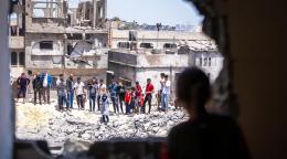 Люди стоят на обломках разрушенных домов