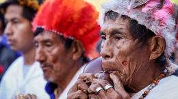 Мужчины в народных головных уборах играет на флейте