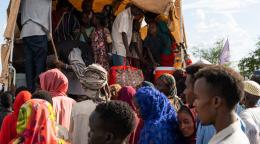 People boarding a cart outdoors, a crowded scene