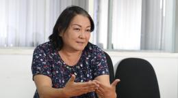 A woman in a black shirt gestures with her hands as she talks
