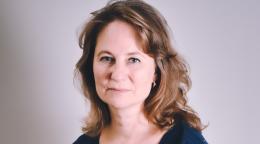 A woman in a dark navy dress with brown hair