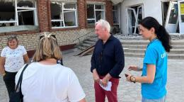 Resident and Humanitarian Coordinator for Ukraine Matthias Schmale (2nd from right) stands in front of a transit centre for displaced people fleeing hostilities in the front-line Donetsk Region.