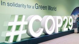 A sign that reads COP29 with a map standing next to it
