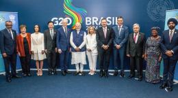 A group of 12 people, heads of delegations of the G20, standing in a line in various formal clothes