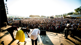 Three people on stage are bowing towards the audience