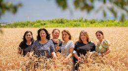 A group of women standing in a field and looking at the camera