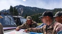 Егеря рассматривают карту местности в горах