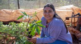 Девушка держит саженец и улыбается