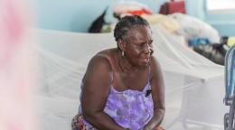 Sonia est assise sur un lit provisoire a l'intérieur du refuge