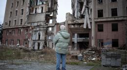 A high-level UN official surveils the damage to a building in Ukraine.