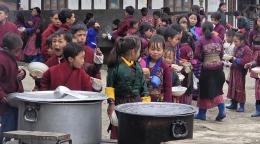 Children in Bhutan line up for their school meal.