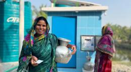 A woman in Bangladesh holds a water jug.