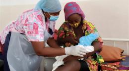 A nurse in Sierra Leone tends to a mother and her baby.