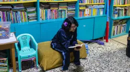 Niña leyendo en la biblioteca