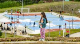A young girl in Costa Rica stands on a hill overlooking a park.