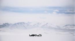 A group of people in Tajikistan in front of snowy mountains.