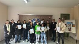 Группа молодых людей держит в руках сертификаты об окончании профессиональной подготовки.