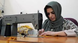 شابة في العراق تستخدم ماكينة خياطة