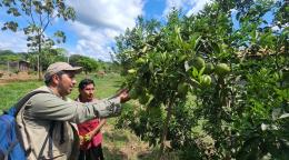 A man in the Bolivian Amazon shows a tree to a UN employee.