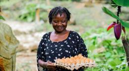 Une agricultrice camerounaise tient une boîte d'œufs.