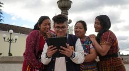 A young man and three women in Guatemala use a tablet.